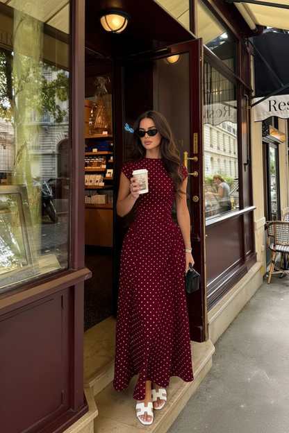 Modelo morena com vestido bordô de bolinhas num café parisiense